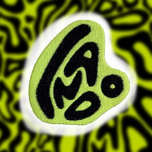 May include: A lime green patch with black embroidered lettering that reads "L.A.M.O."