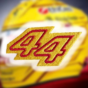 May include: A yellow and red embroidered patch with the number "44" in a bold, outlined font.