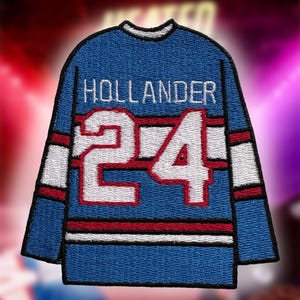 以下が含まれることがあります： 「HOLLANDER」の文字と数字「24」が白で刺繍された青いホッケーユニフォームパッチ。ユニフォームのデザインには、袖と裾に赤と白のストライプが含まれています。パッチはスポーツをテーマにしたアイテムです。