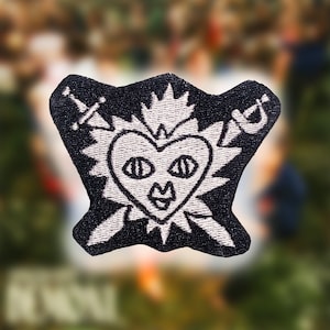 May include: Black embroidered patch with a white heart with eyes and a mouth, surrounded by a white crown of thorns and two swords.