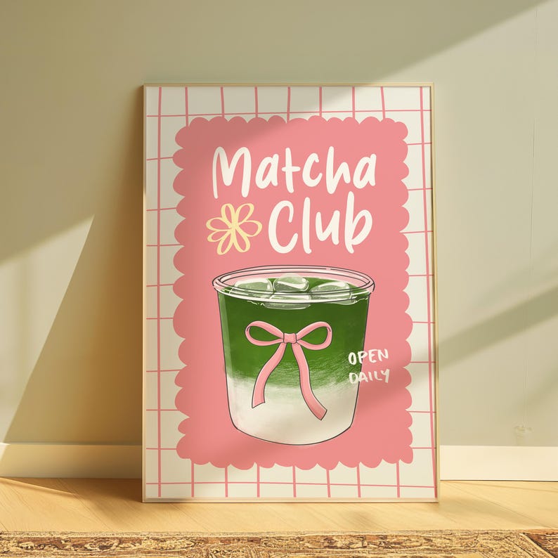 May include: A framed print featuring a matcha drink illustration. The artwork showcases a green beverage with ice cubes in a clear glass, adorned with a pink bow. The words "Matcha Club" are written in white, with "Open Daily" below.