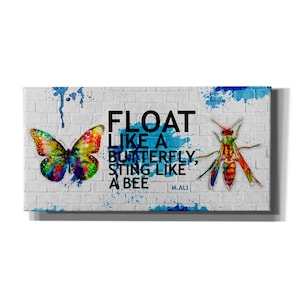 May include: A white brick wall with blue and green paint splatters. The text "FLOAT LIKE A BUTTERFLY, STING LIKE A BEE" is written in black. The quote is attributed to "M. ALI". A colorful butterfly and a wasp are painted on the wall.