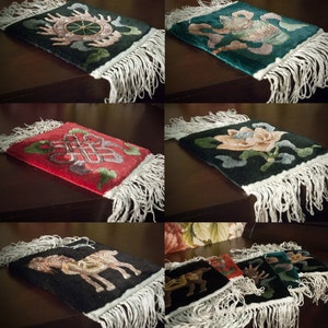 May include: Set of six colorful Tibetan prayer rugs with intricate designs and fringed edges. The rugs feature traditional symbols and motifs, including a wheel, a lotus flower, and a knot.