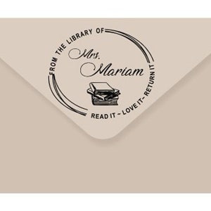 May include: A black and white stamp with the text "From the Library of Mrs. Mariam Read it - Love it - Return it" and a stack of books.
