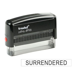 以下が含まれることがあります： 「trodat printy 4916」というテキストと「SURRENDERED」という単語が刻印された黒い自動インクスタンプです。