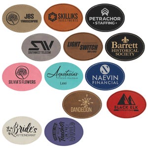May include: A collection of oval-shaped leather patches in various colors, each with a different logo or text. The patches feature logos for businesses like "JBS Yardscaping," "Skilliks Investments," and "Petrachor Staffing."