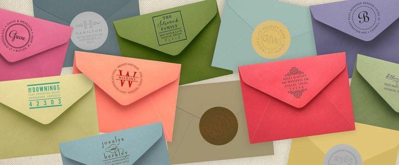 K&ouml;nnte beinhalten: Eine Sammlung von Umschl&auml;gen mit verschiedenen personalisierten Briefmarken. Die Briefmarken zeigen verschiedene Designs, darunter Initialen, Familiennamen und dekorative Muster. Die Umschl&auml;ge sind in verschiedenen Farben, darunter rosa, gr&uuml;n, blau und rot.