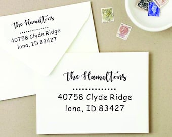 Könnte beinhalten: Ein weißer Umschlag mit einem schwarzen Absenderaufkleber, auf dem "The Hamiltons" steht, gefolgt von der Adresse "40758 Clyde Ridge, lona, ID 83427".