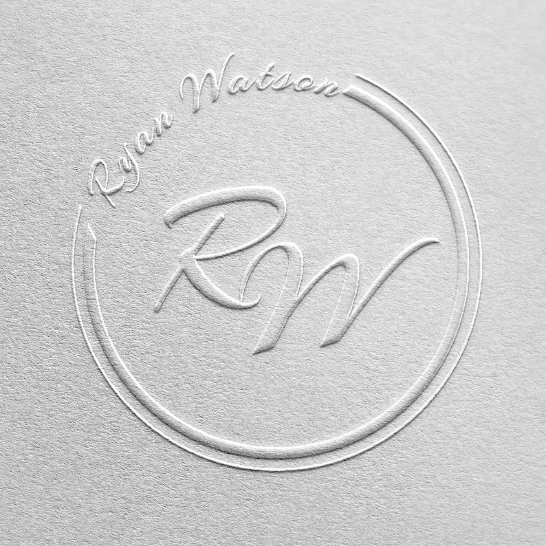 以下が含まれることがあります： 「Ryan Watson」というテキストと、スタイリッシュなフォントで書かれたイニシャル「RM」が刻まれた白いエンボス加工の円です。