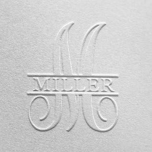 May include: A white, embossed monogram with the last name "MILLER" centered below the letter "M".
