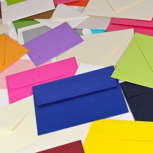 May include: A variety of colorful envelopes in different shades of red, orange, yellow, green, blue, purple, and white. The envelopes are arranged in a random pattern on a white surface.