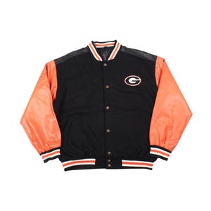 May include: Black and orange varsity jacket with a white and black striped collar, cuffs, and hem. The jacket features orange sleeves, a black body, and a small logo on the chest. The jacket has a button-up front.