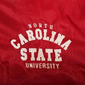 gift for alumni student, back to school outfit, high end thrift find, autumn layering basic, retro university look, classic americana clothing, cozy stadium wind shell, campus fashion trend, curated vintage boutique
