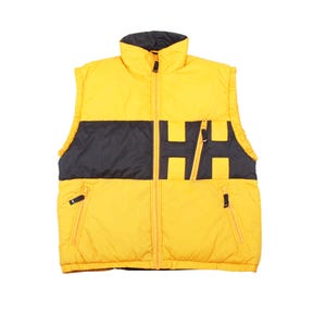 May include: A yellow and black puffer vest with a high collar and a full-length zip. The vest features black panels across the chest and the letters "HH" in black. Two zipped pockets are visible on the front.