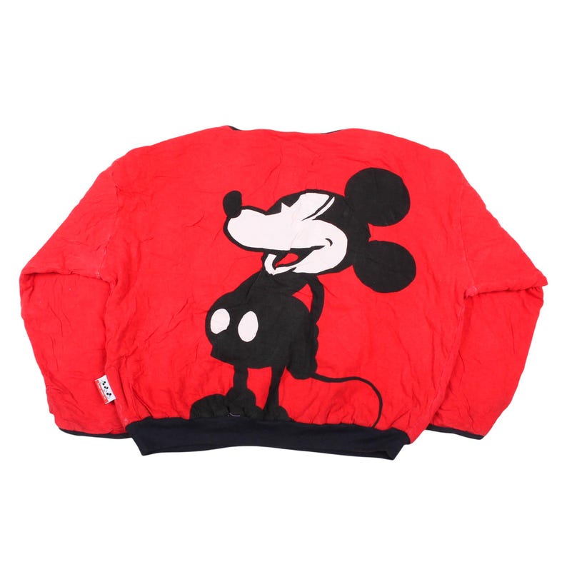 Vintage 90s Disney reversible sweatshirt red side view featuring a massive black and white stitched Mickey Mouse character patch on the center
