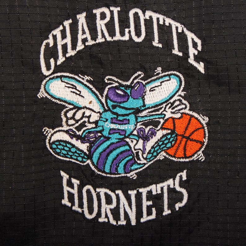 charlotte basketball , teal sportswear , nba retro clothing , 90s charlotte gear , vintage hip hop style , teal accent jacket , oversized retro coat , baggy streetwear , y2k sports jacket , mens activewear coat , authentic nba merch , team logo jacket , throwback sports , fashion collector item , retro hip hop jacket , trendy mens outerwear , vintage fan apparel , street fashion usa , nylon zip up , american sports style