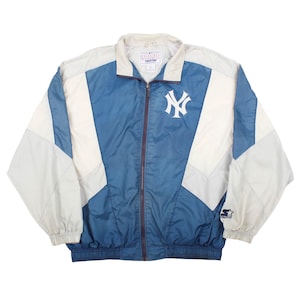 May include: A blue and off-white color-blocked zip-up windbreaker jacket featuring the New York Yankees logo on the left chest. The jacket includes a high collar, long sleeves with elastic cuffs, a front zipper closure, and a Starter brand logo.
