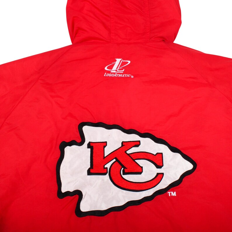 May include: A bright red hooded jacket featuring the Kansas City Chiefs arrowhead logo in white with red lettering and a black outline. The LogoAthletic brand logo is printed in white above the team emblem on the back of the garment.