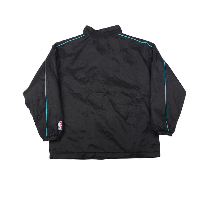 May include: Black nylon jacket with a high collar and turquoise trim along the shoulders and sleeves. Includes an NBA logo patch on the left sleeve. A lightweight, casual outerwear garment.