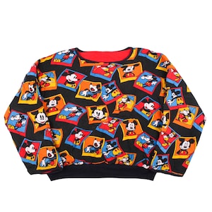⁠Vintage 90s Disney Mickey Mouse reversible sweatshirt featuring an all-over print of colorful Mickey cartoon polaroid frames