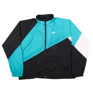 Peut inclure: Un coupe-vent Nike présentant un design color-block en noir, bleu sarcelle vif et blanc. La veste possède un col montant, une fermeture éclair intégrale sur le devant, des manches longues avec poignets élastiques et un petit logo Nike blanc.