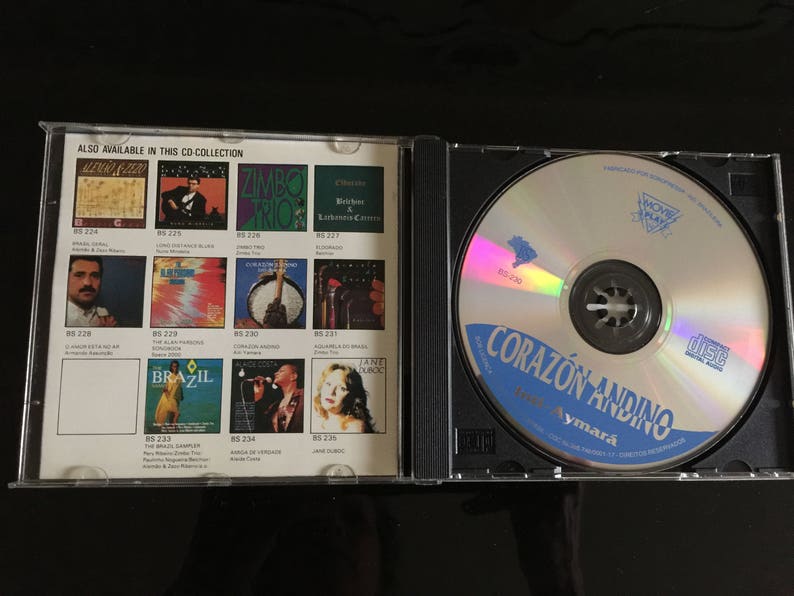 May include: A CD case with a blue and white CD inside. The CD case has a list of other CDs available in the collection. The CD is titled "Corazon Andino" with the text "Aymara" below it.