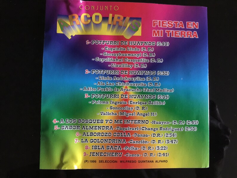 Puede incluir: Una colorida portada de CD con el t&iacute;tulo "Fiesta en mi tierra" y una lista de canciones en espa&ntilde;ol. La portada presenta un dise&ntilde;o de arco&iacute;ris y el nombre del grupo musical "Conjunto Arco Iris".