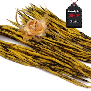 May include: A bundle of yellow and black wool dreadlocks. The dreadlocks are approximately 61 cm long and are ready to be added to your hair.