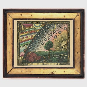 May include: A framed vintage print with a celestial theme. The artwork features a detailed illustration of the sun, moon, stars, and a figure in a red robe. The frame is a combination of dark brown and gold tones, adding to the antique aesthetic.