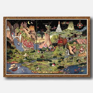 May include: A framed vintage map titled "The Land of Make Believe." The map features a whimsical, illustrated landscape with castles, rivers, and fantastical elements. The frame is ornate with a gold finish, enhancing the map's antique aesthetic.