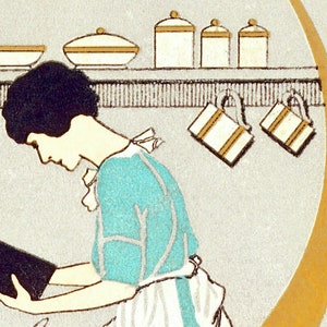 May include: A woman in a turquoise dress and white apron is reading a black cookbook in a kitchen. The kitchen has a shelf with white bowls and jars.
