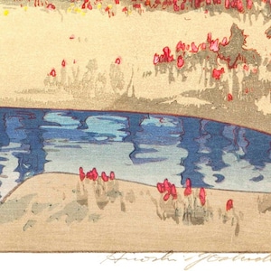 May include: A colorful woodblock print depicting a serene landscape. The artwork features a blue river reflecting the sky, a sandy bank, and red and yellow foliage. The artist's signature is visible in the bottom right corner.