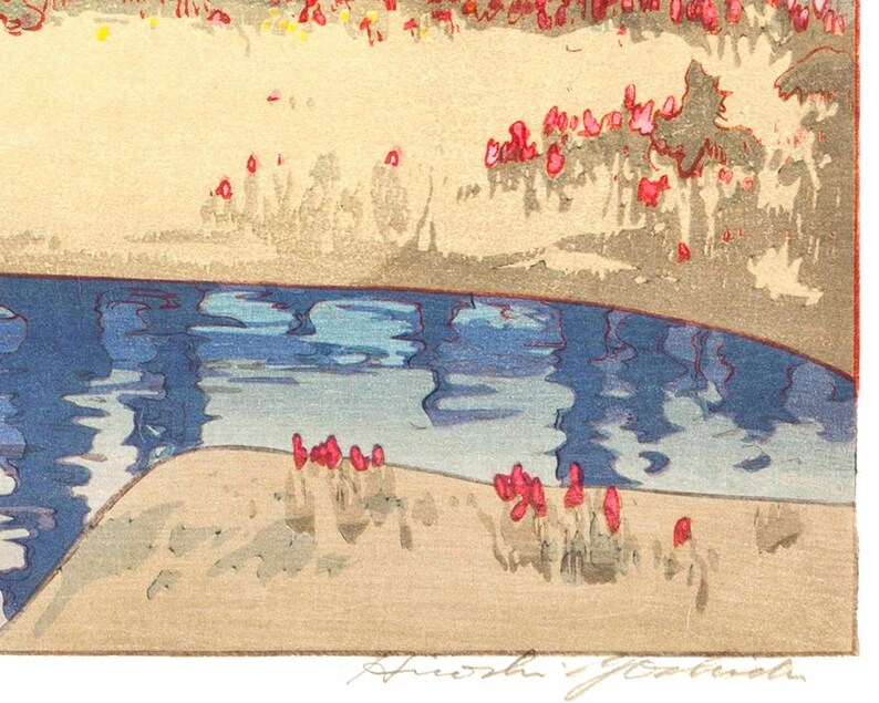 May include: A colorful woodblock print depicting a serene landscape. The artwork features a blue river reflecting the sky, a sandy bank, and red and yellow foliage. The artist's signature is visible in the bottom right corner.