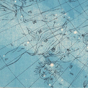 May include: A vintage celestial chart with a blue background and white stars. The chart depicts the constellation Andromeda, with a detailed illustration of the mythical figure Andromeda chained to a rock.