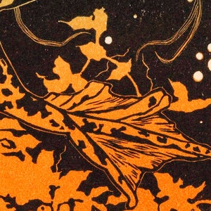 May include: A black and orange leaf with a detailed vein pattern against a dark background with white dots.