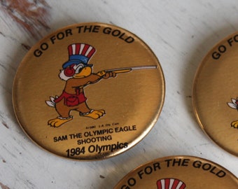 Sam The Olympic Eagle "Go For the Gold" LA Olympic Games Sport Shooting Button Pin Lot or Single Pin, Rifle, Pistol, Shotgun, Pentathlon