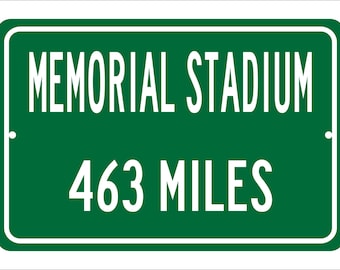 May include: A green road sign with white lettering that reads "MEMORIAL STADIUM 463 MILES".
