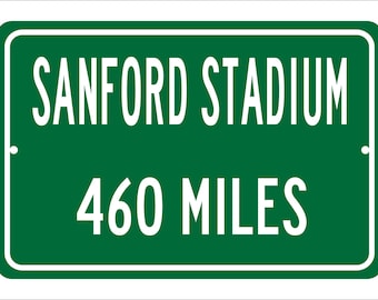 Pode incluir: Uma placa de estrada verde com letras brancas que diz "SANFORD STADIUM 460 MILES".