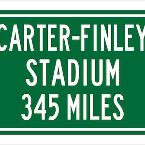 May include: Green road sign with white text that reads "Carter-Finley Stadium 345 Miles".