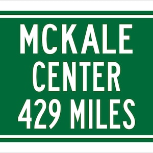 May include: Green road sign with white text that reads "McKale Center 429 Miles".