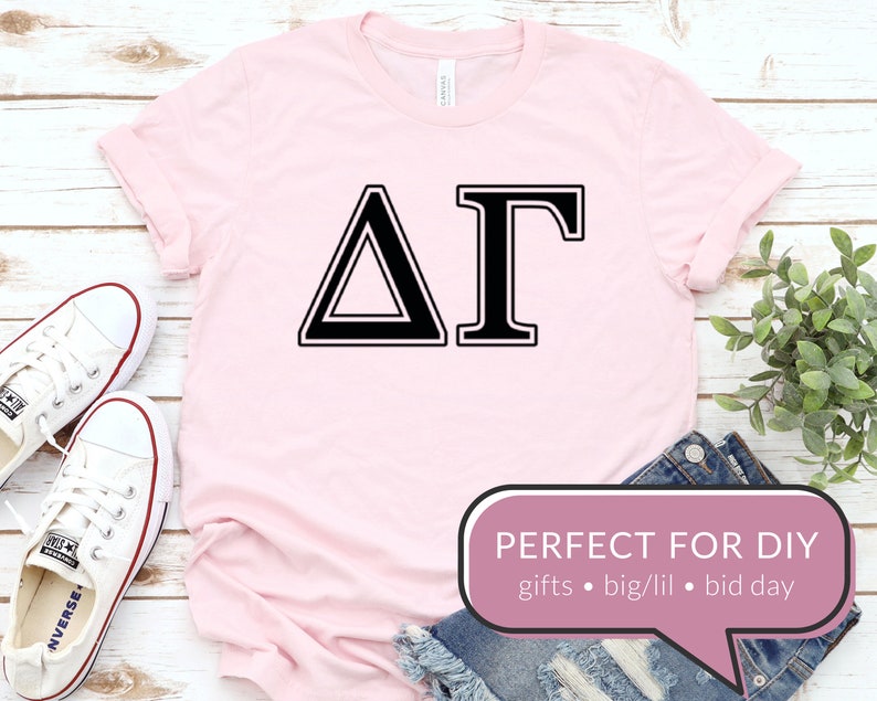 May include: Pink t-shirt with a black Delta Gamma sorority Greek letter design. The text "PERFECT FOR DIY" is in a speech bubble with the words "gifts, big/lil, bid day".