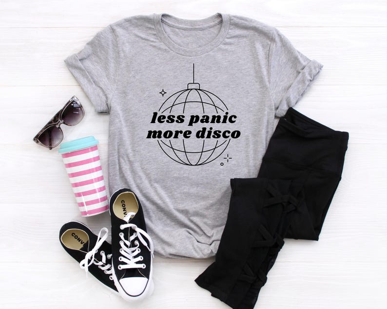 May include: A gray t-shirt with a black and white graphic of a disco ball and the text "less panic more disco".