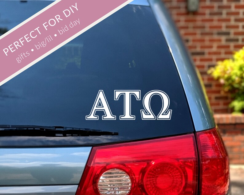 May include: White vinyl decal with the letters "ATO" on a blue car window.