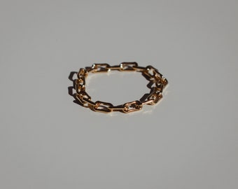 May include: A gold chain ring with a simple, linked design.