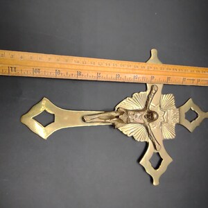 K&ouml;nnte beinhalten: Ein goldfarbenes Metallkreuz mit einer detaillierten Figur von Jesus Christus. Das Kruzifix ist etwa 30 cm lang.