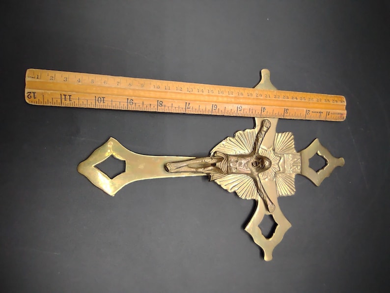 K&ouml;nnte beinhalten: Ein goldfarbenes Metallkreuz mit einer detaillierten Figur von Jesus Christus. Das Kruzifix ist etwa 30 cm lang.