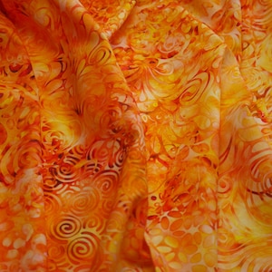 May include: Orange and yellow fabric with a swirling pattern. The fabric is soft and flowing, with a subtle sheen.
