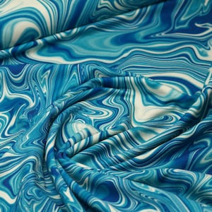Op de afbeelding: Blauw en wit abstract swirl-patroon stof. De stof is zacht en vloeibaar, met een zijdeachtige textuur.
