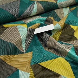 Op de afbeelding: Teal, geel en bruin stof met een geometrisch patroon van strepen en driehoeken.