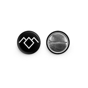 May include: Black and white button with a geometric mountain symbol. The back of the button is silver.
